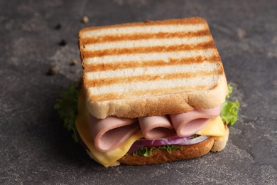 Delicious sandwich with boiled sausage, cheese and onion on grey textured table, closeup