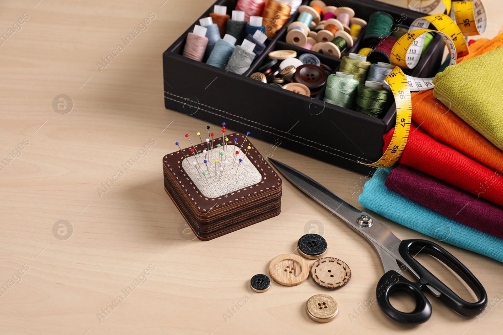 Photo of Set of sewing supplies and accessories on wooden table