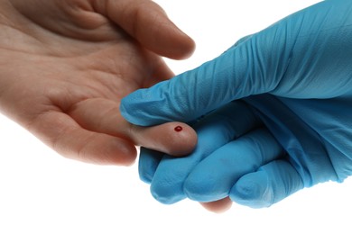Photo of Doctor taking blood sample from patient's finger on white background, closeup