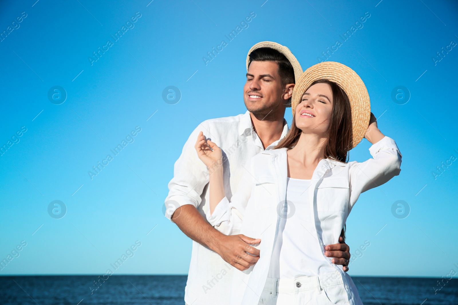 Photo of Lovely couple wearing hats together on beach