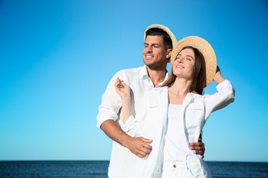 Photo of Lovely couple wearing hats together on beach