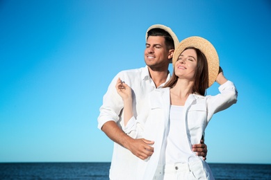 Lovely couple wearing hats together on beach