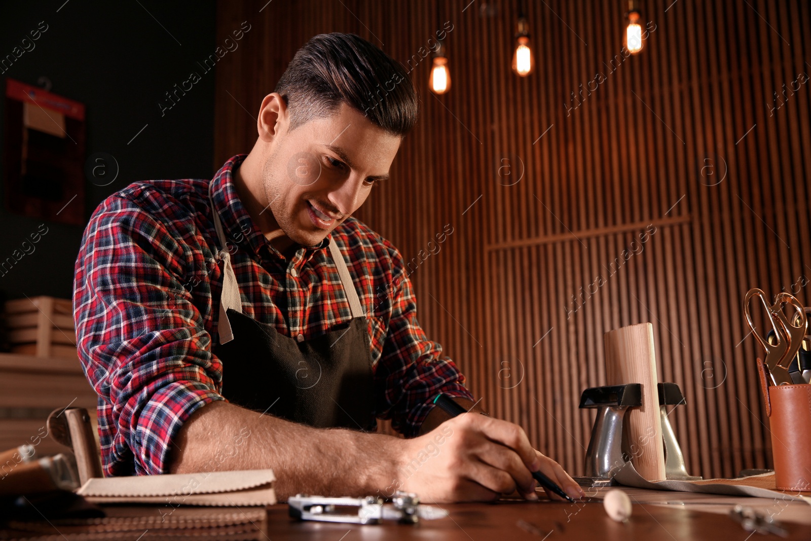 Photo of Man working with piece of leather in workshop