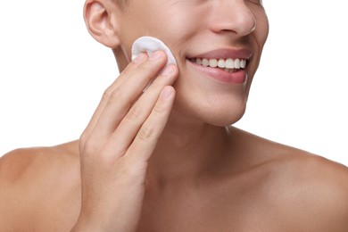 Man cleaning face with cotton pad on white background, closeup