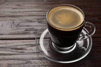 Photo of Cup of aromatic coffee on wooden table, closeup. Space for text