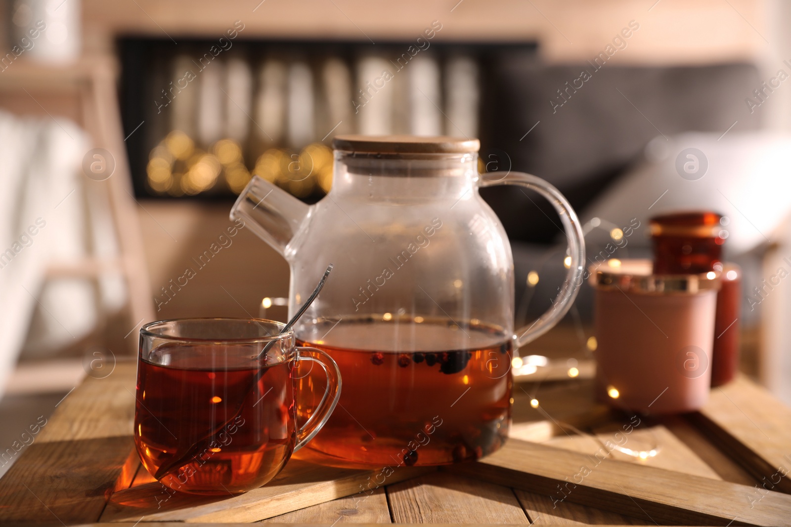 Photo of Teapot and cup with hot tea on table indoors