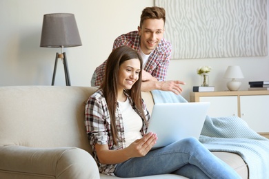 Happy young couple with laptop, indoors