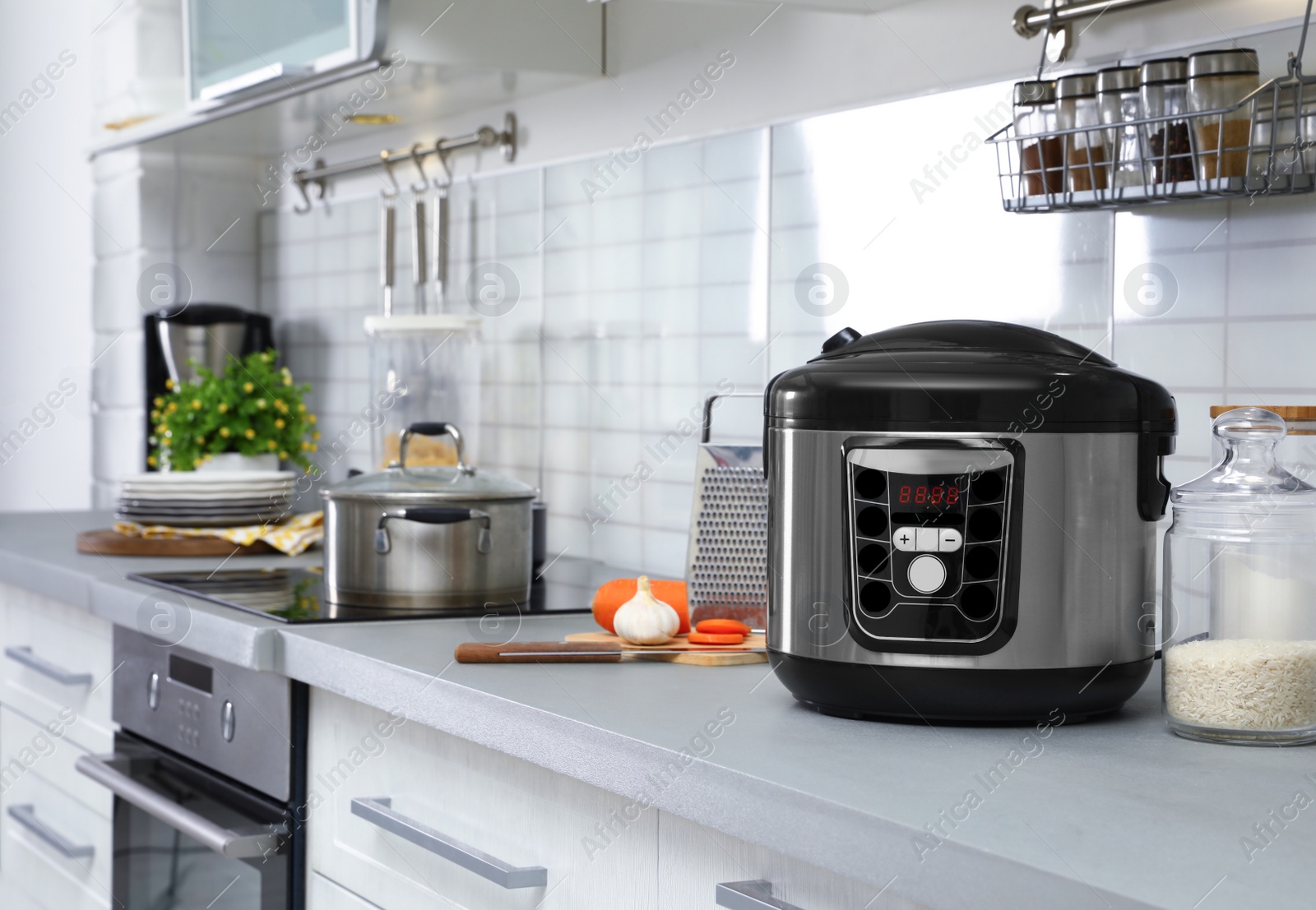 Photo of Modern multi cooker and products on table in kitchen. Space for text