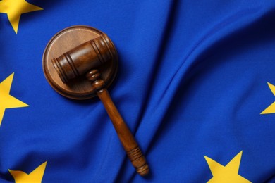 Photo of Wooden judge's gavel on flag of European Union, top view. Space for text