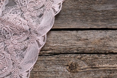 Photo of Beautiful lace on wooden table, top view. Space for text