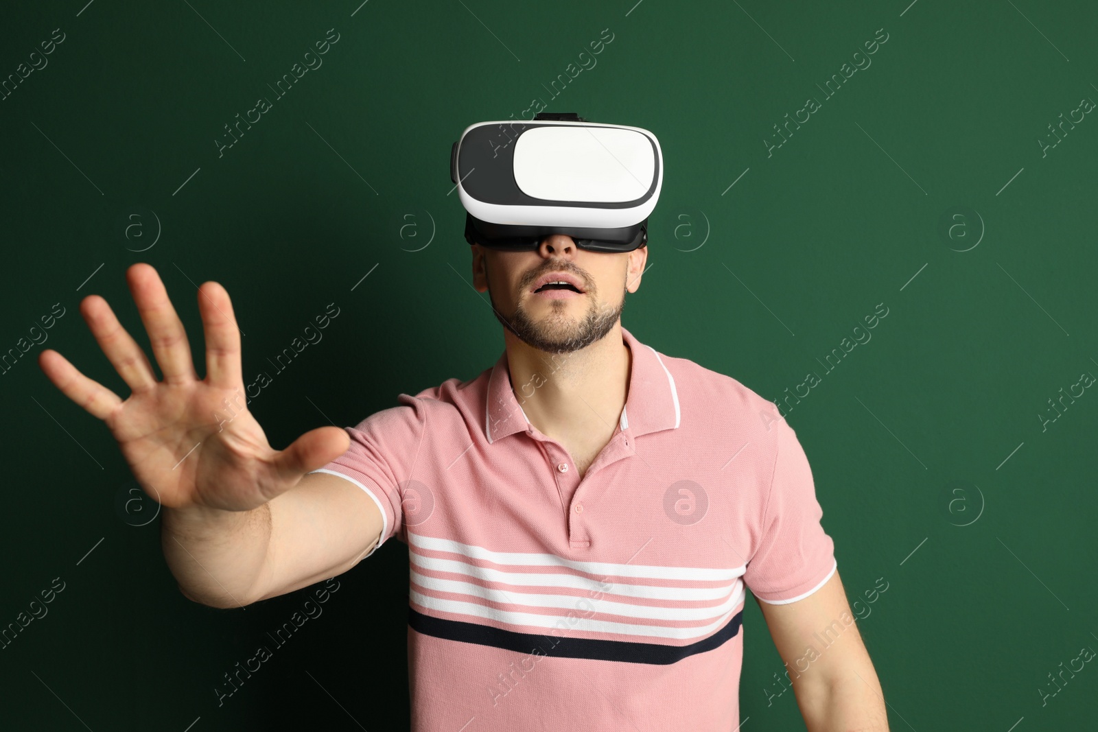 Photo of Man using virtual reality headset on green background