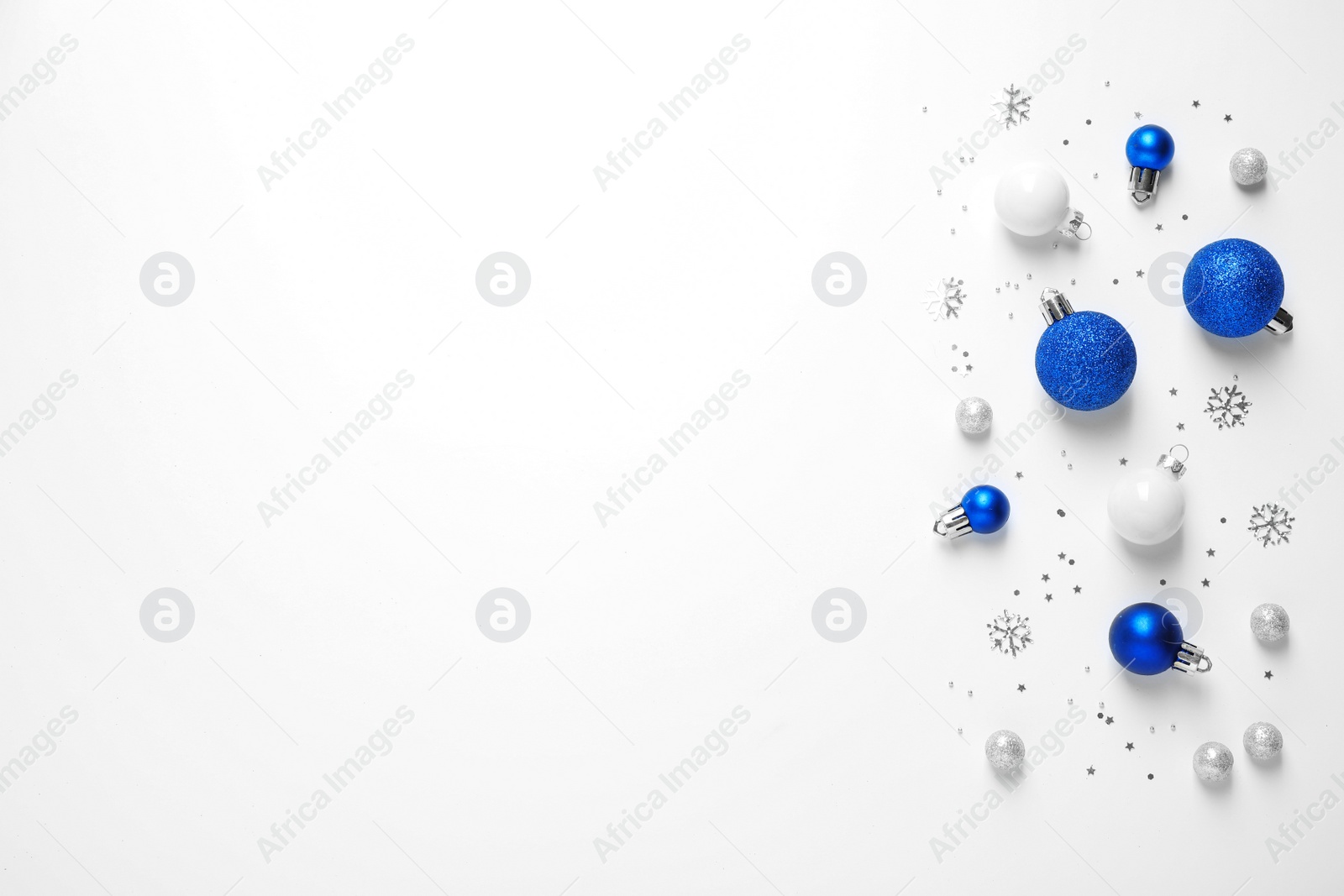 Photo of Colorful Christmas balls and sparkles on white background, top view