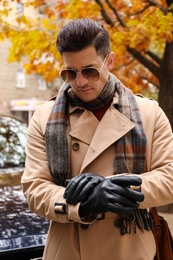 Photo of Handsome stylish man wearing black leather gloves outdoors