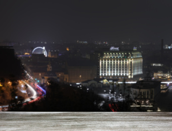 Image of Empty wooden surface and blurred view of night city