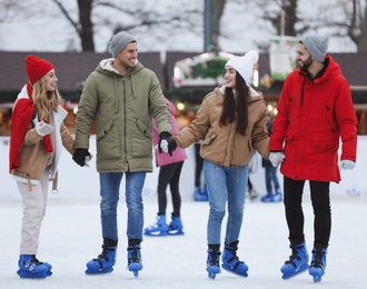 Image of Group of friends skating at outdoor ice rink