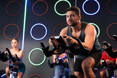 Photo of Group of people training on exercise bikes in fitness club