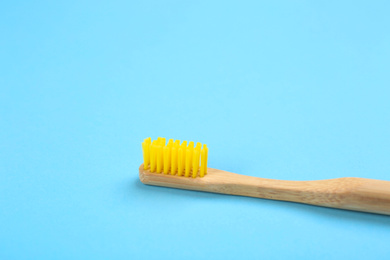 Toothbrush made of bamboo on light blue background