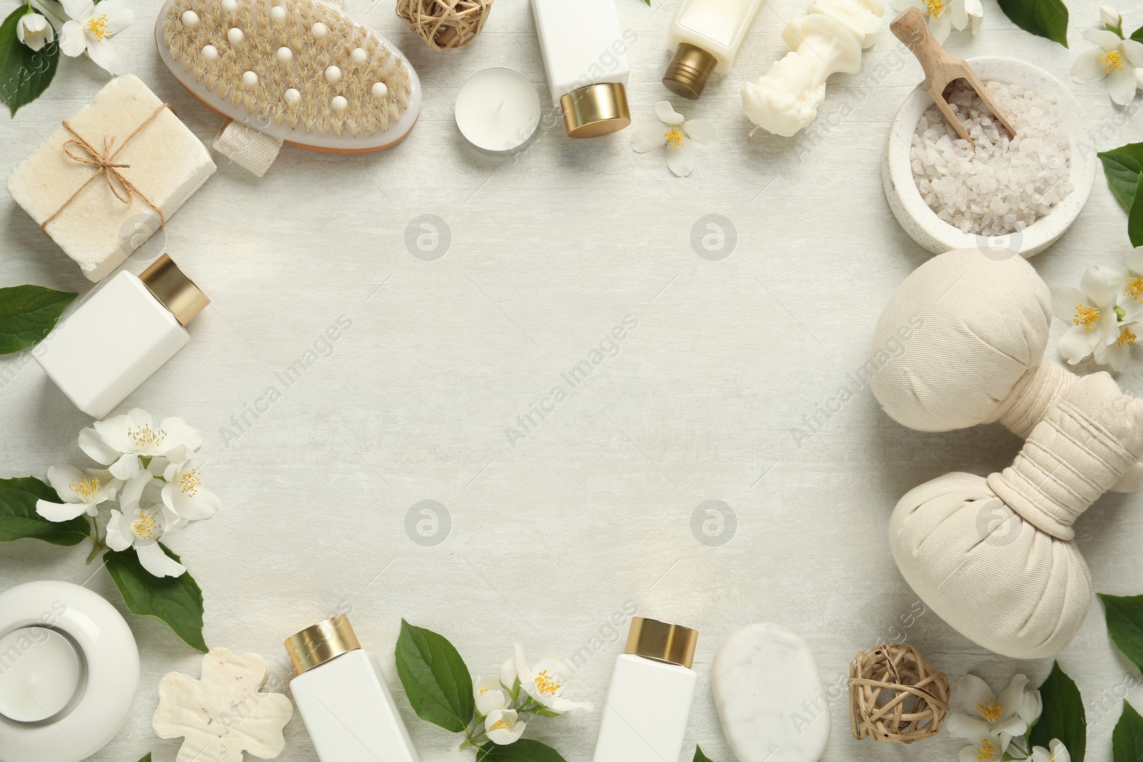 Photo of Jasmine flowers and set of spa essentials on white wooden table, flat lay. Space for text