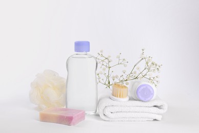 Photo of Different skin care products for baby in bottles, gypsophila and accessories on white background