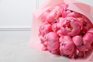 Bouquet of beautiful pink peonies on white table, closeup. Space for text