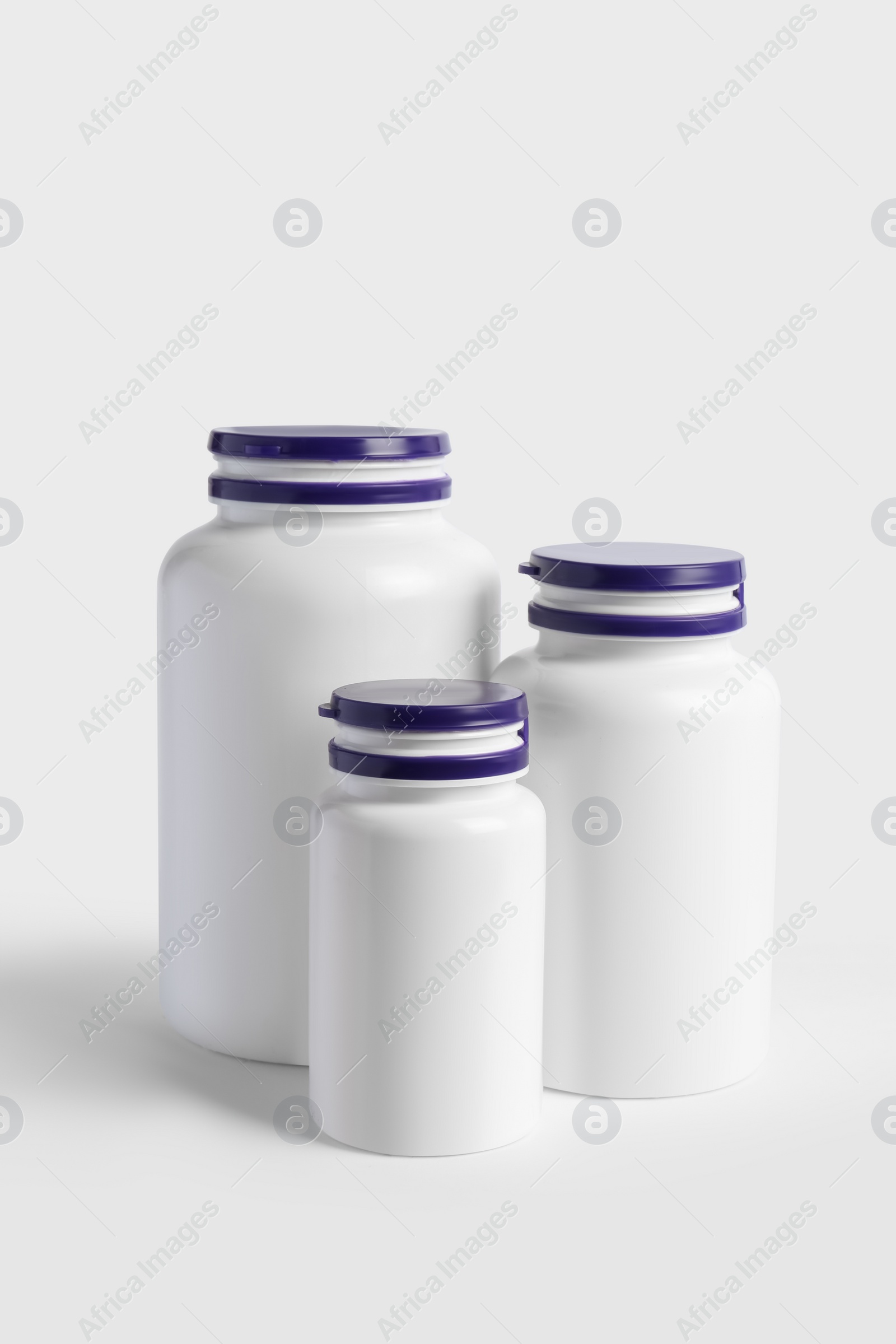 Photo of Closed plastic medicine bottles on white background. Medicament