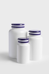 Photo of Closed plastic medicine bottles on white background. Medicament