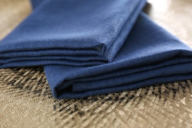 Photo of Blue kitchen napkins on textured background, closeup