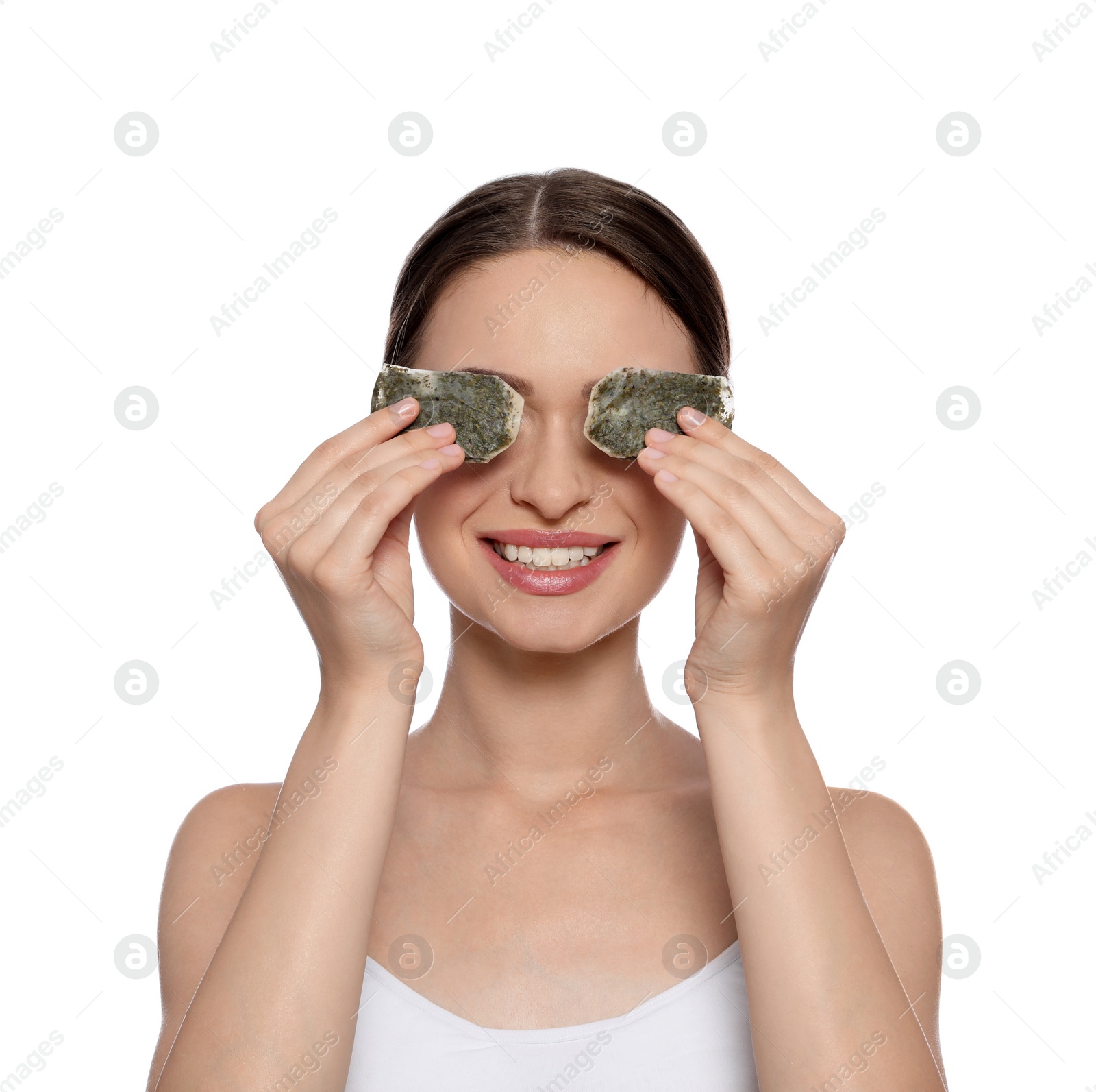 Photo of Young woman with green tea bags on white background. Eye skin care