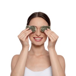 Young woman with green tea bags on white background. Eye skin care