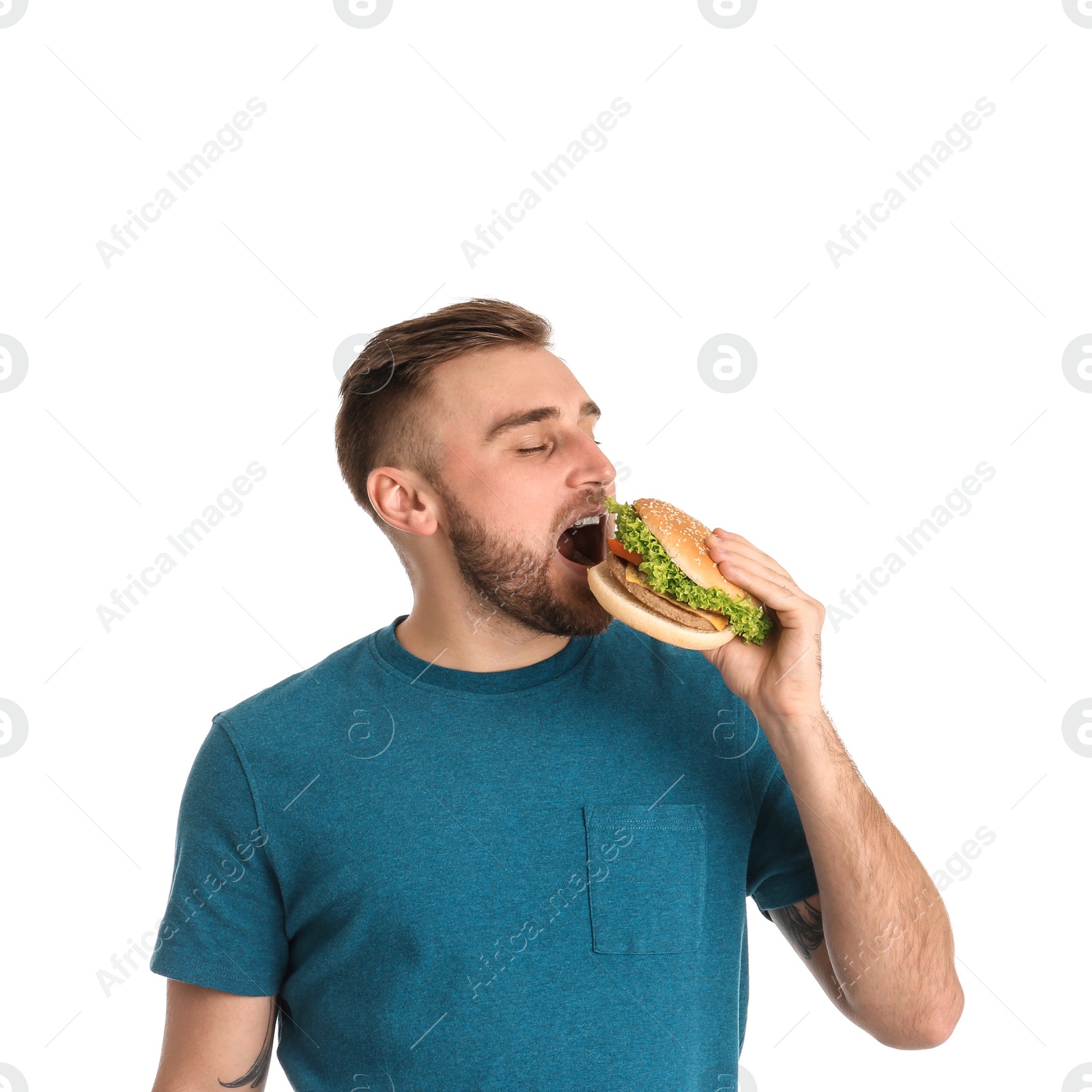 Photo of Young man eating tasty burger on white background