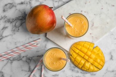 Photo of Glasses of fresh mango drink and fruits on table, top view