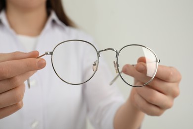Photo of Woman with glasses on light background, closeup