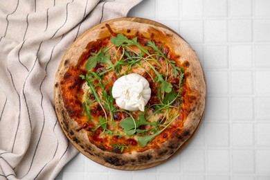 Delicious pizza with burrata cheese and arugula on white tiled table, top view