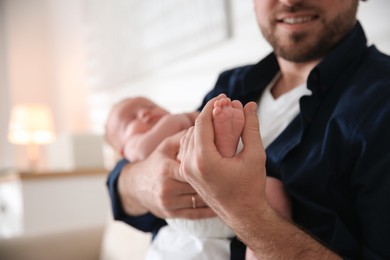 Father with his newborn son at home, closeup