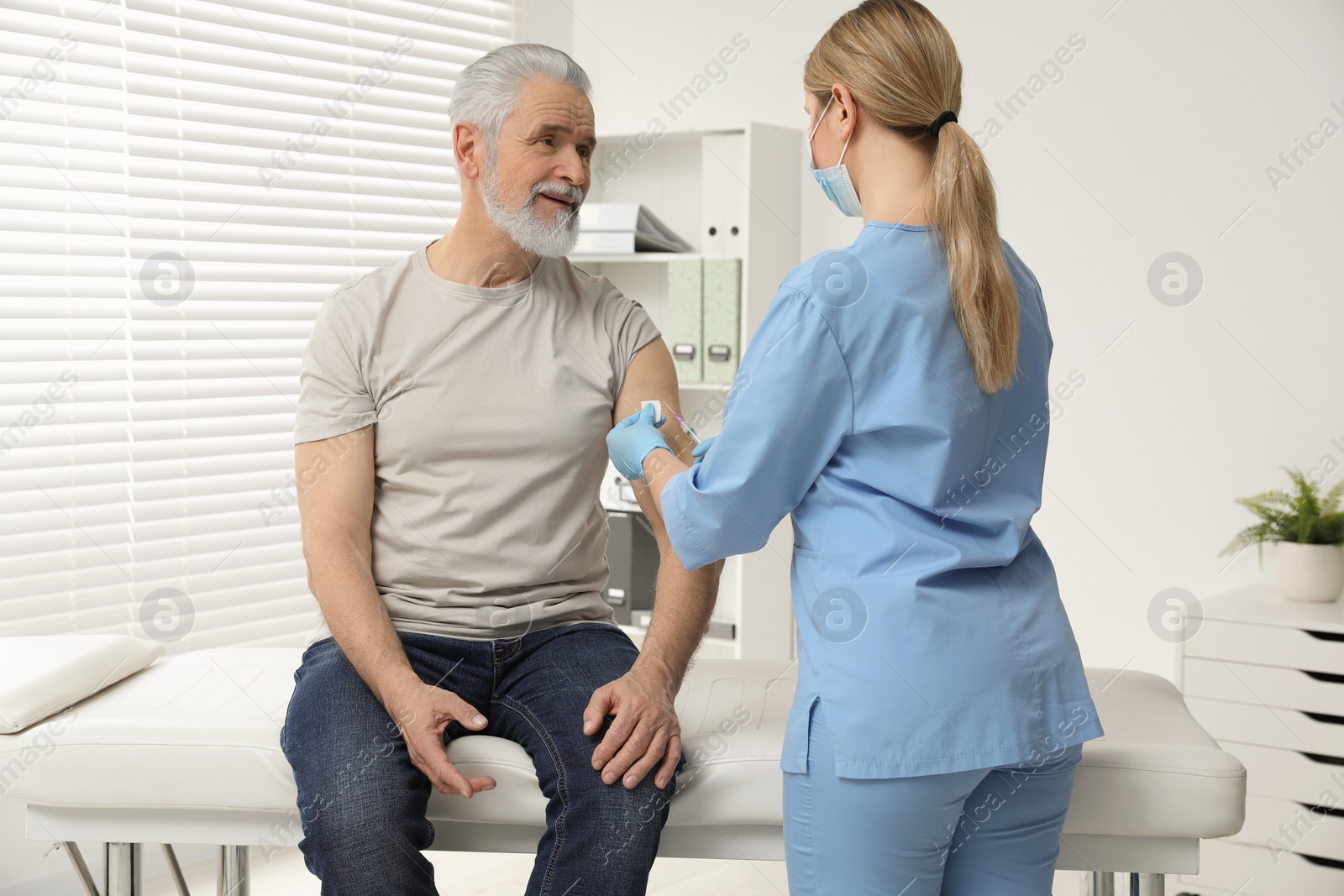 Photo of Doctor giving hepatitis vaccine to patient in clinic