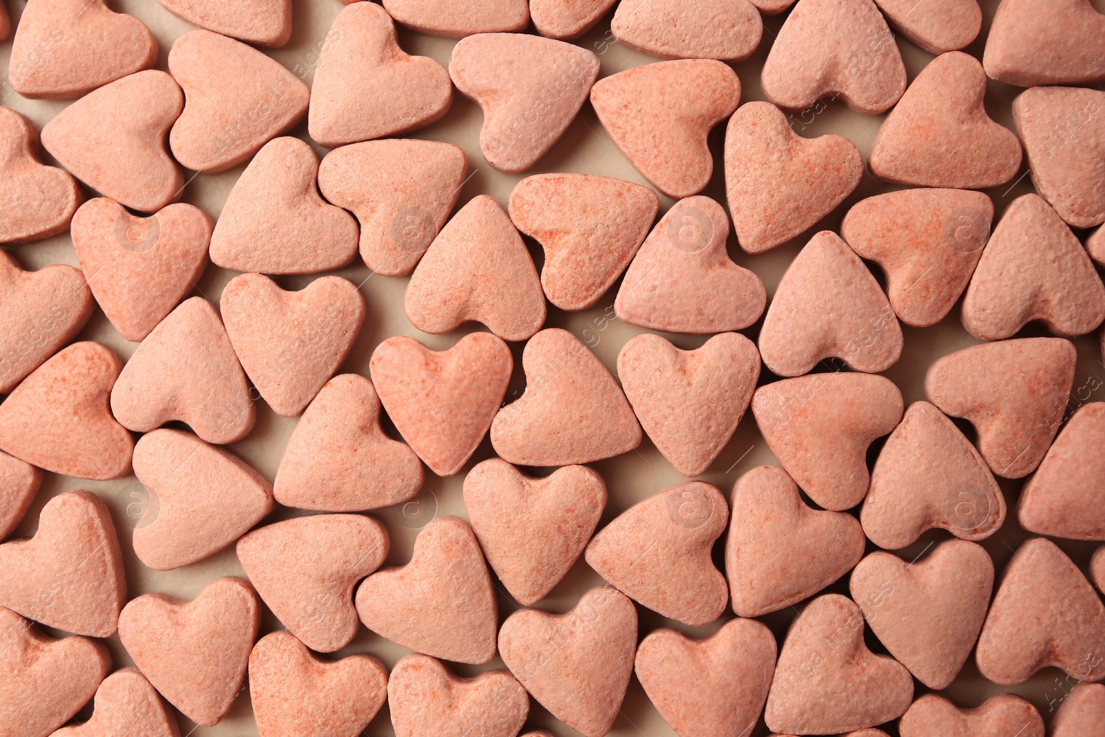 Photo of Many heart shaped vitamins for pets on beige background, flat lay