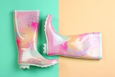 Pair of gumboots on color background, top view. Female shoes