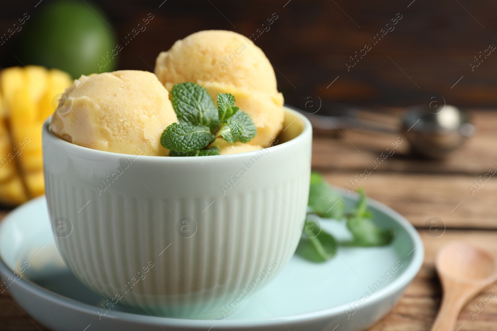 Photo of Delicious mango ice cream served on table, closeup