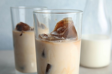 Photo of Glass of milk with coffee ice cubes on blurred background, closeup