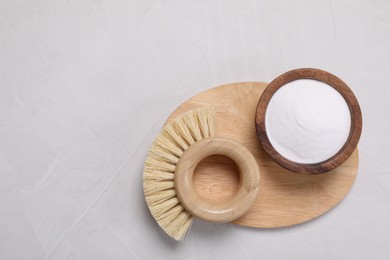 Photo of Cleaning brushes and baking soda on white table, top view. Space for text