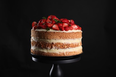 Photo of Tasty cake with fresh strawberries and mint on black background