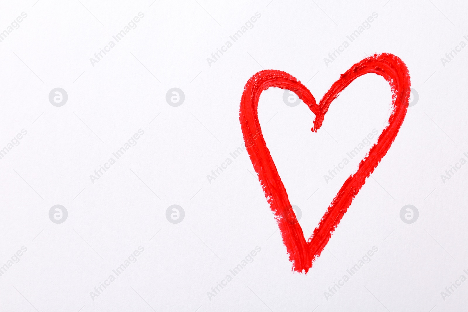 Photo of Heart drawn with red lipstick on white paper, top view