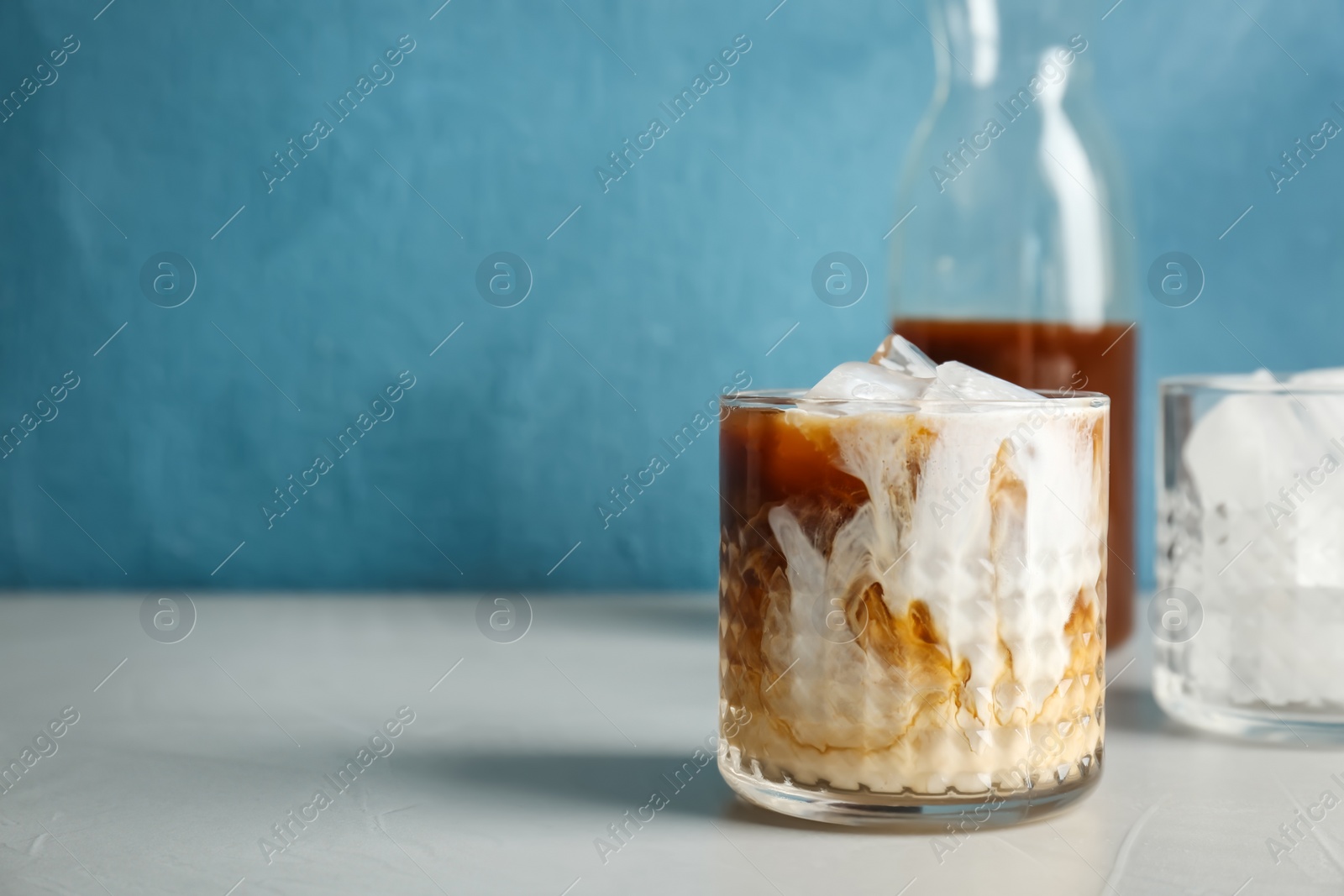 Photo of Glass with cold brew coffee and milk on table