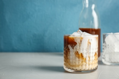 Glass with cold brew coffee and milk on table