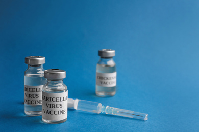 Photo of Chickenpox vaccine and syringe on blue background. Varicella virus prevention