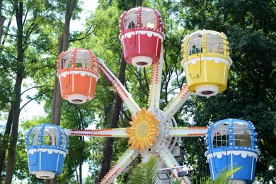 Observation wheel with colorful cabins in amusement park