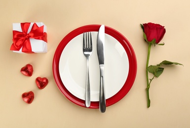 Photo of Beautiful table setting for Valentine's Day dinner on beige background, flat lay