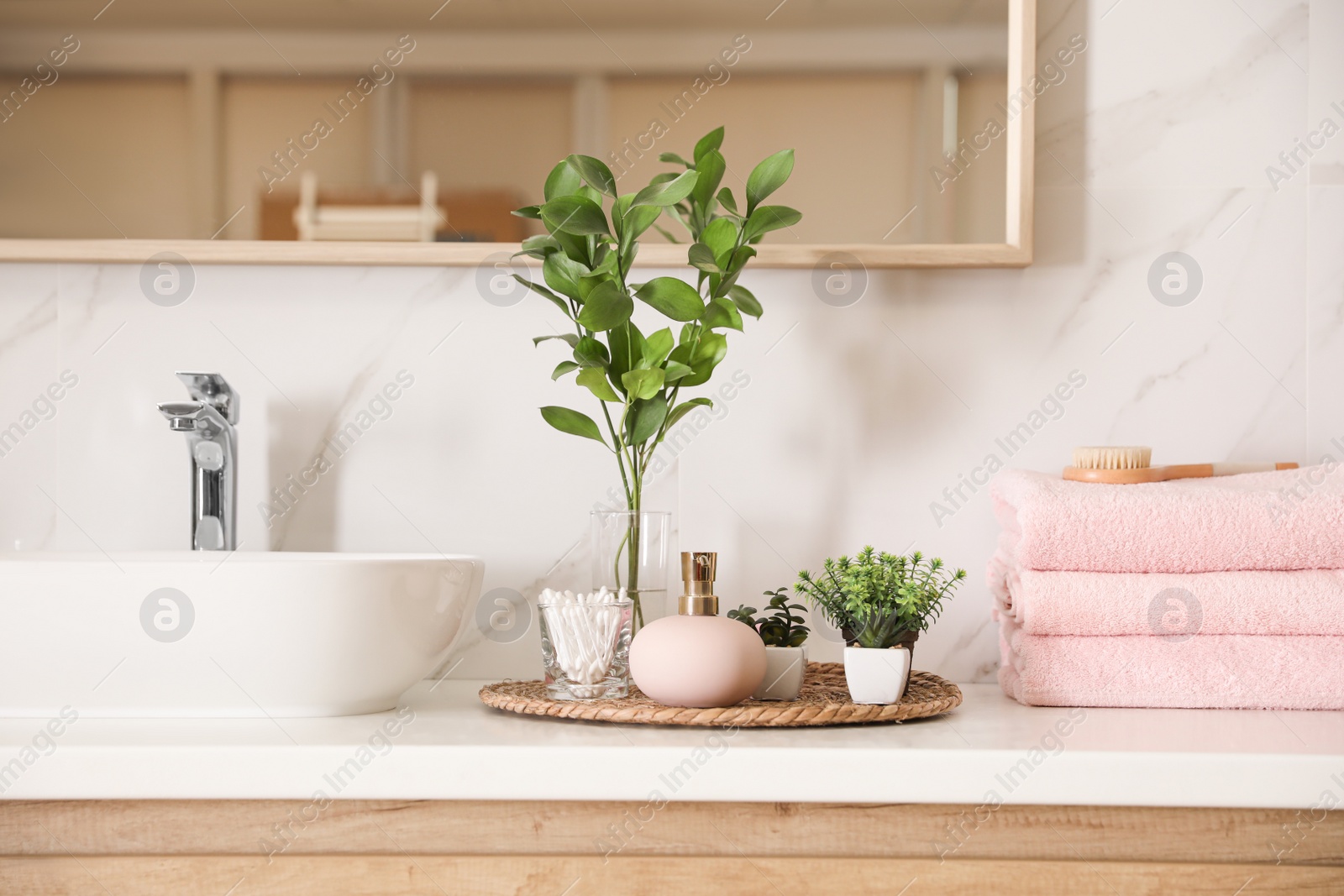 Photo of Green plants and toiletries on white countertop in bathroom. Interior design