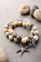 Beautiful bracelets with gemstones on grey background, closeup