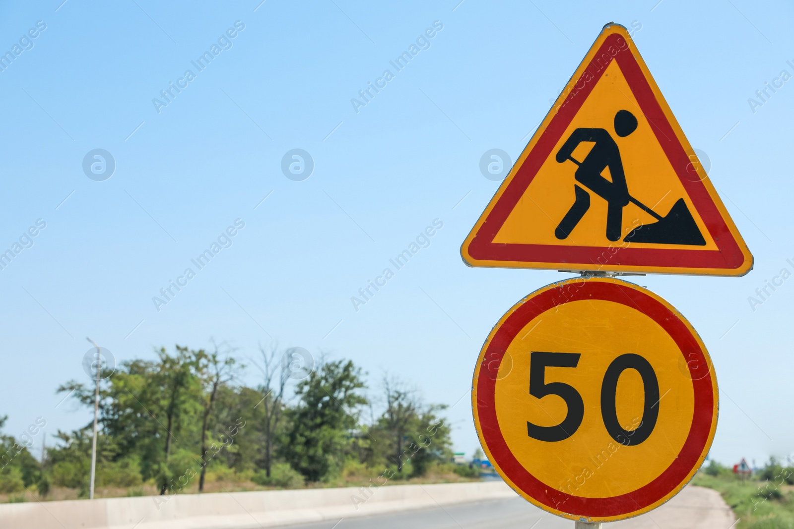 Photo of Road construction and speed limit signs outdoors on sunny day. Repair works